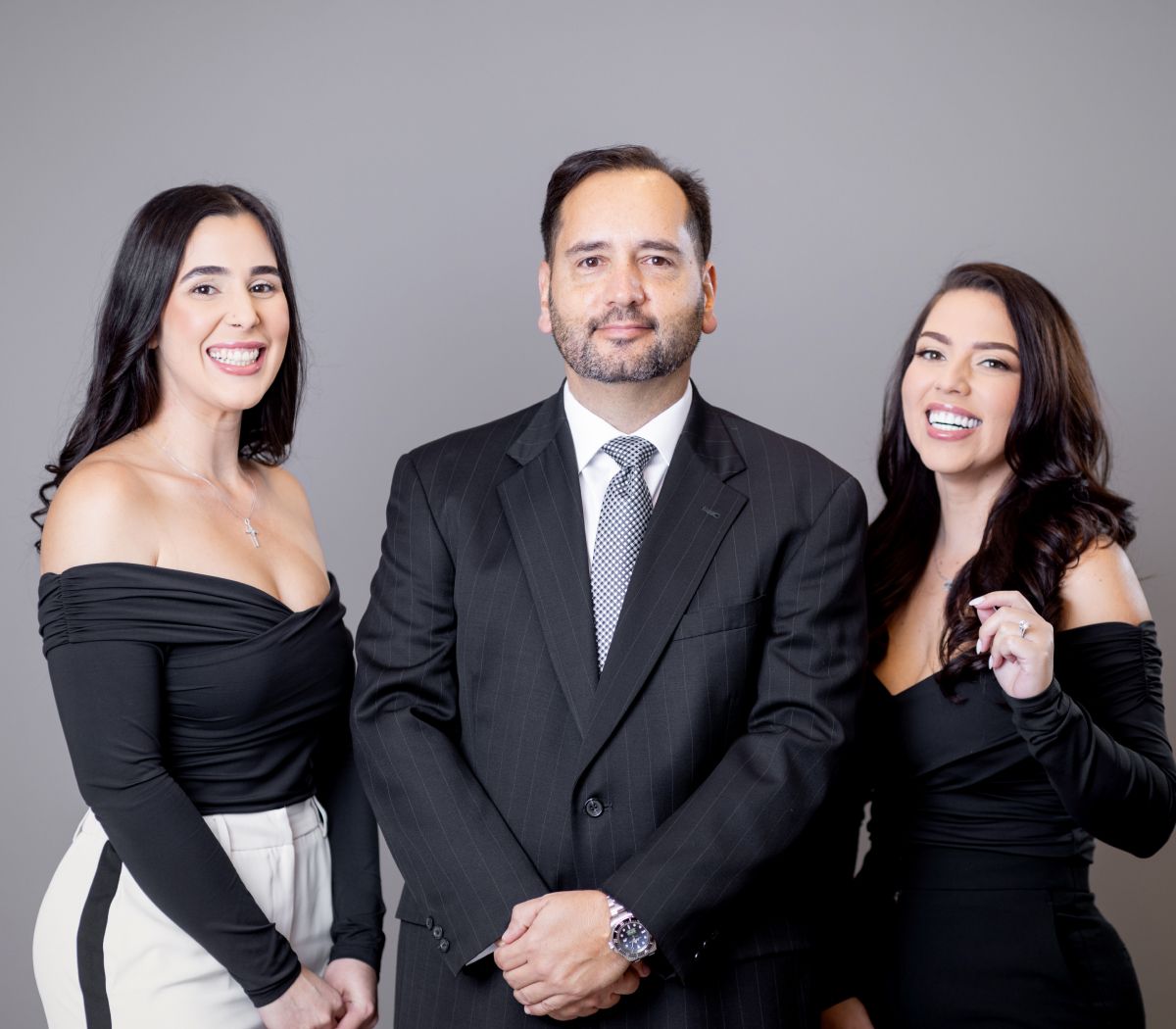 Three professionals posing confidently in formal attire