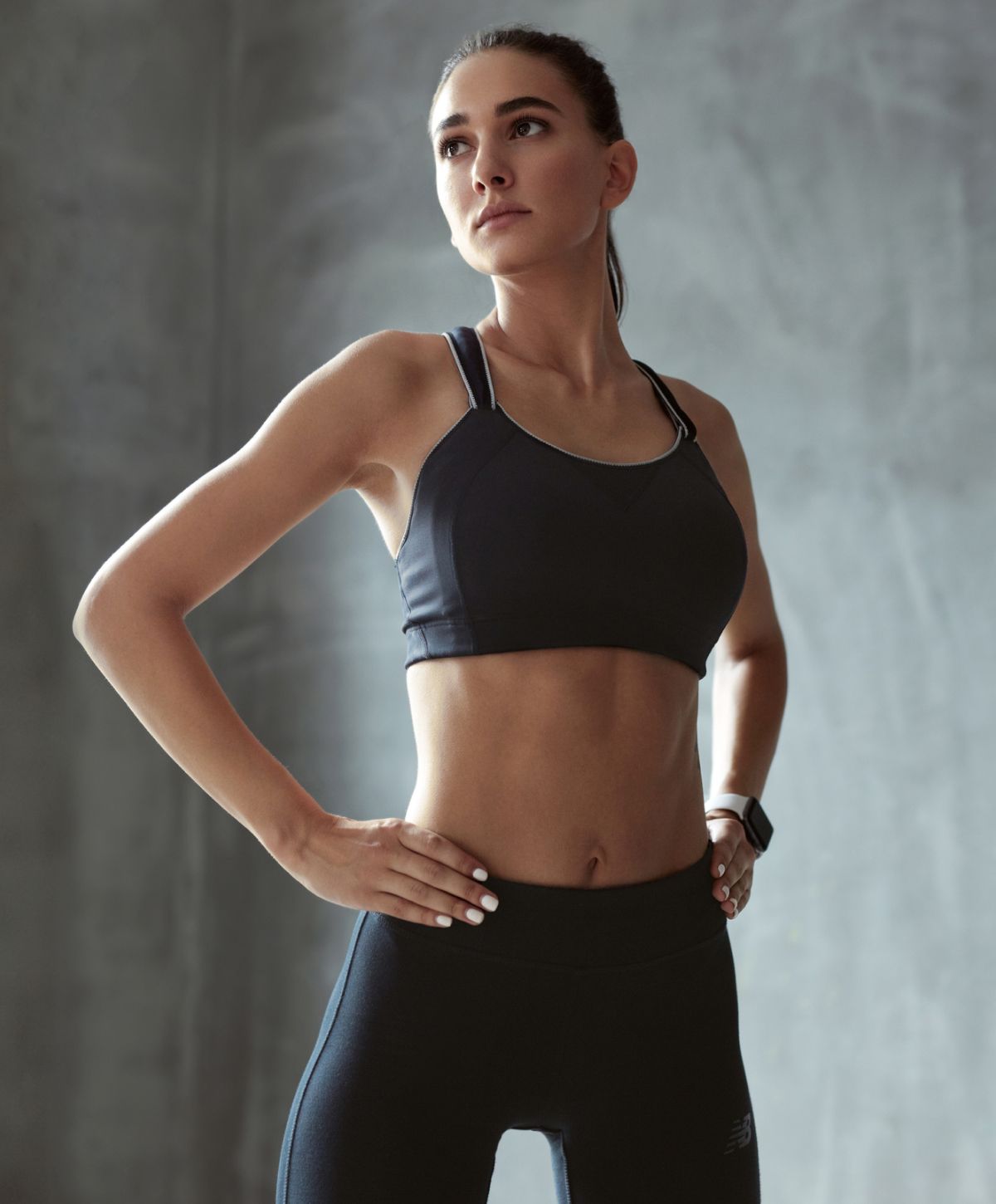 Athletic woman posing confidently in workout attire.