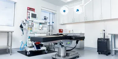 Modern surgical room with equipment and operating table.